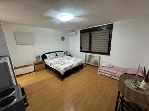 Una pequeña habitación con una cama y una ventana. en Apartment Dedić, en Sarajevo