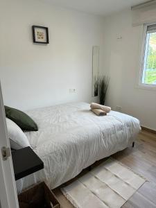 ein weißes Bett in einem weißen Schlafzimmer mit einem Fenster in der Unterkunft O Refuxio da Ría in Pontevedra