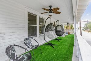 een veranda met stoelen en een plafondventilator bij San Marco Villa Duplex w Backyard BBQ & Firepit in St. Augustine