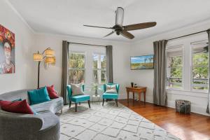 een woonkamer met een bank, stoelen en ramen bij San Marco Villa Duplex w Backyard BBQ & Firepit in St. Augustine