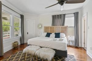 een slaapkamer met een groot bed met blauwe kussens en een plafondventilator bij San Marco Villa Duplex w Backyard BBQ & Firepit in St. Augustine +40 foto's