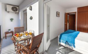 einen Balkon mit einem Tisch, Stühlen und einem Bett in der Unterkunft Hola Sitges Apartments in Sitges