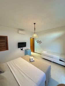 a bedroom with a bed and a flat screen tv at Flats Elementus Preá in Prea +64 photos