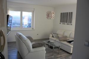 a living room with two white couches and a window at Bella Vita in Postojna