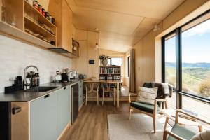 a kitchen and living room in a tiny house at Snowgrass Hut - Above & Beyond in Mount Somers