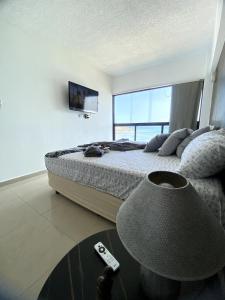 una camera da letto con un letto e una TV a parete di Encantador Refugio frente al mar a Porlamar