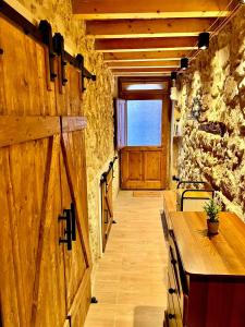 a hallway with a wooden door and a wooden table at Asturie Home in Siracusa