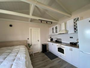 a kitchen with white cabinets and a bed in a room at Blue Horizon Rock-Sea View Apartment in Nidri in Nydri