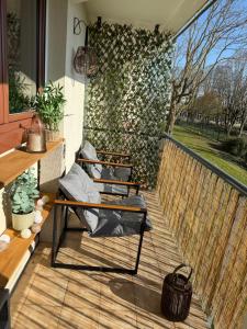 a patio with two chairs on a wooden deck at Le Cocon in Beauvais
