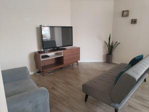 a living room with a couch and a flat screen tv at Bonito departamento en cercado in Tacna