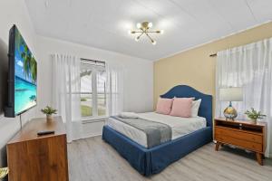 a bedroom with a blue bed and a tv at SUPER BOHO - At Lake Toho Fishing VINTaGE VIBEs in Kissimmee