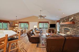 a living room with leather furniture and a stone fireplace at 164 Jillian - Private peaceful retreat in Three Rivers