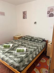 a bed with green pillows on it in a room at Nova Čubura in Šid +9 photos