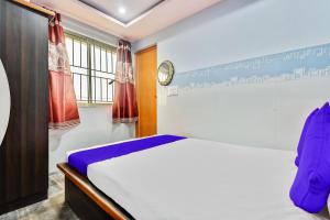 a bedroom with a white bed and a window at SPOT ON Gayatri Comforts in Bengaluru