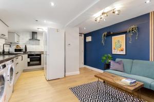 a living room with a couch and a blue wall at Ashton Getaway Sleeps 14 Free Parking in Dukinfield +42 photos