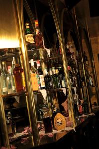 a shelf filled with lots of bottles of alcohol at Hotel Diplomat Palace in Rimini