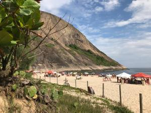 een groep mensen op een strand met een berg bij Pousada por do sol in Niterói +8 foto's