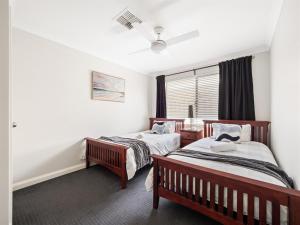 a bedroom with two beds and a window at Busselton Broadwater Holiday Home in Busselton