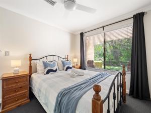 a bedroom with a bed and a large window at Busselton Broadwater Holiday Home in Busselton