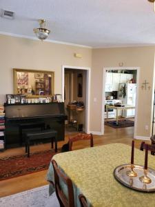 a living room with a table and a piano at Cozy Charming Vintage Villa in Oxford