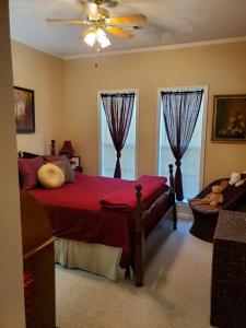 a bedroom with a red bed and two windows at Cozy Charming Vintage Villa in Oxford