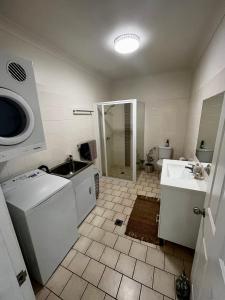 a bathroom with a sink and a washing machine at Downtown Narrabri Apartment in Narrabri +11 photos