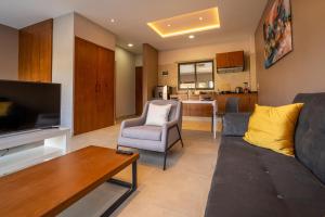 a living room with a couch and a tv at Terrah Suites Oaxaca in Oaxaca City