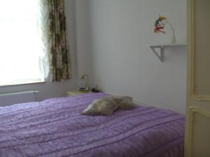 a bed with a purple comforter in a bedroom at Rodd in Roddan