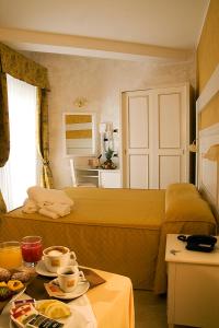 a hotel room with a bed and a table with food at Hotel Diplomat Palace in Rimini