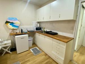 a small kitchen with white cabinets and a microwave at Modern Studio Room Retreat in Harristown