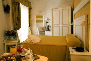a small bedroom with a bed and a table at Hotel Diplomat Palace in Rimini