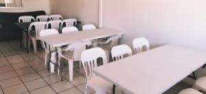 a room with white tables and white chairs at Salón y habitaciones 783 in Rosarito Beach