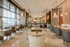a restaurant with tables and chairs in a room at AC Hotel Firenze by Marriott in Florence