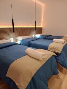un gruppo di letti in una camera con lenzuola blu di Apart Hotel Selah a Santa Isabel Altre 18 foto