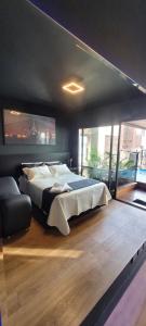 a bedroom with a large bed and a large window at Morumbi, Apartamento Pub, SPA com hidromassagem, PISCINA Aquecida PRIVATIVA, LAREIRA, tudo que você precisa para descansar, trabalhar ou realizar aquela comemoração! Com total conforto e PRIVACIDADE! O Apt Nota 10 de SP! in São Paulo +78 photos