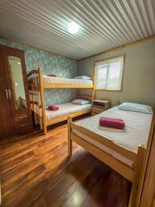 Habitación con 2 literas y espejo. en Cabaña Aquiles, en Puerto Natales