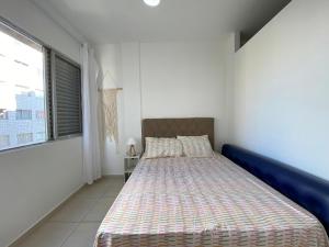 a white bedroom with a bed and a window at Kit dos Sonhos – Frente Mar na Tupi! in Samaritá