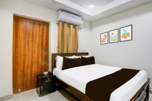 MadhapurSuper Collection O Madhapur Near Cyber Tower的卧室里有一张白色的床和一扇木门
