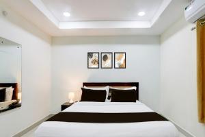 MadhapurSuper Collection O Madhapur Near Cyber Tower的卧室配有白色墙壁的床