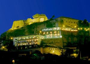a building in front of a mountain at night at Hotel Residence Due Mari in Marcellinara