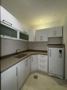 a kitchen with white cabinets and a sink and a refrigerator at شاليه خاص ومميز بتصميم عصري ومواصفات حديثة STaY1 in Riyadh