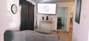 a living room with a couch and a television at Salón y habitaciones in San Patricio +36 photos