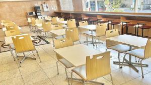 Toyoko Inn Tokuyama-eki Shinkansen-guchi في Shunan: فصل فيه طاولات وكراسي في كفتريا