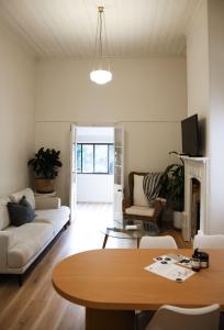 ビーチワースにあるClements Cottage on Main St. Bare bnb by Bare Body Beauty co.のソファとテーブルのあるリビングルーム
