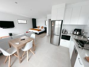 a kitchen and living room with a couch and a table at Views on Sapphire - Brand New - Adults Only in Merimbula