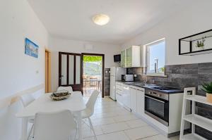 a kitchen and dining room with a table and chairs at Seaside apartments with a swimming pool Tri Zala, Korcula - 558 in Korčula