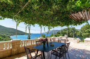 a blue table and chairs on a patio with the ocean at Seaside apartments with a swimming pool Tri Zala, Korcula - 558 in Korčula