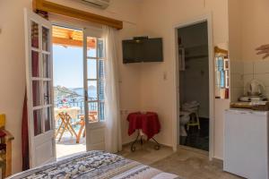 a room with a bed and a kitchen with a balcony at Melina's Sunset in Myrties