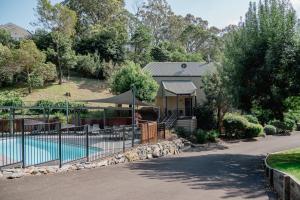 a house with a swimming pool and a fence at Candlebark at Boardwalk Villas Metung in Metung