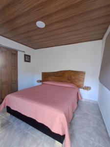 a bedroom with a bed with a wooden headboard at El Guaney Campestre in Somondoco +11 photos